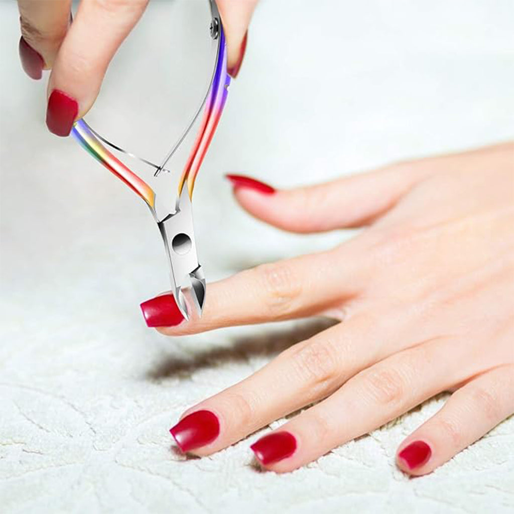 Aardlig CuticleCare Tool in use, precisely trimming cuticles on a hand with red nails.